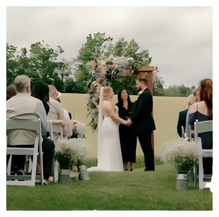 Couple exchanging vows in an outdoor wedding ceremony surrounded by guests.